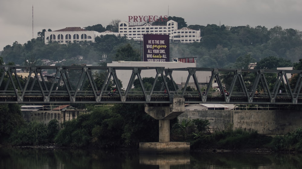 a bridge over a body of water with a building in the background