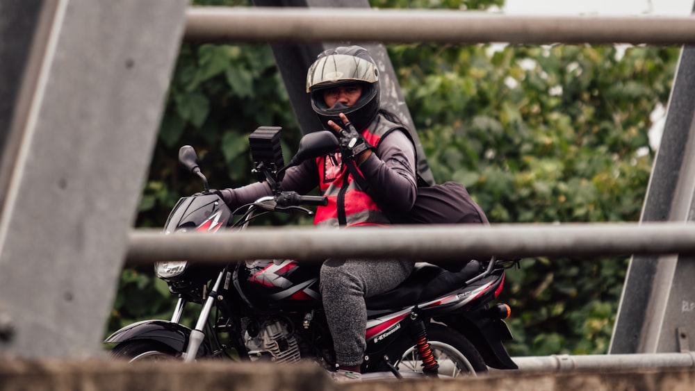 a person sitting on a motorcycle on a bridge