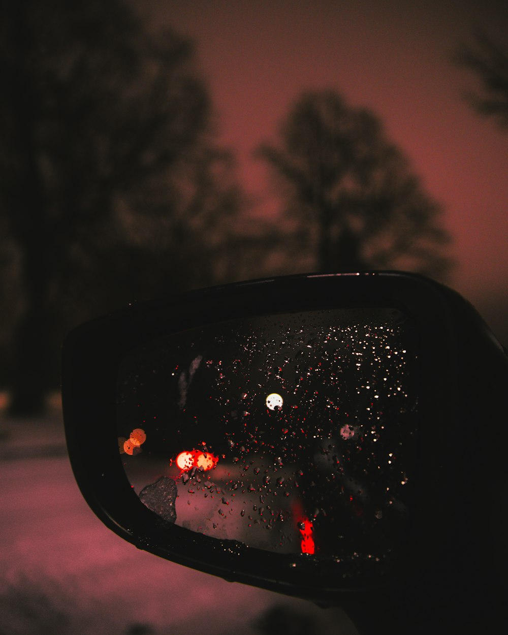 a rear view mirror of a car at night