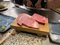 a couple of pieces of raw meat on a cutting board