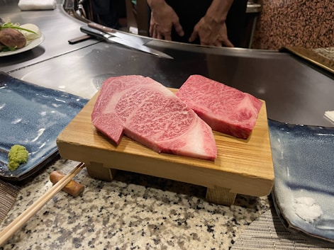 a couple of pieces of raw meat on a cutting board