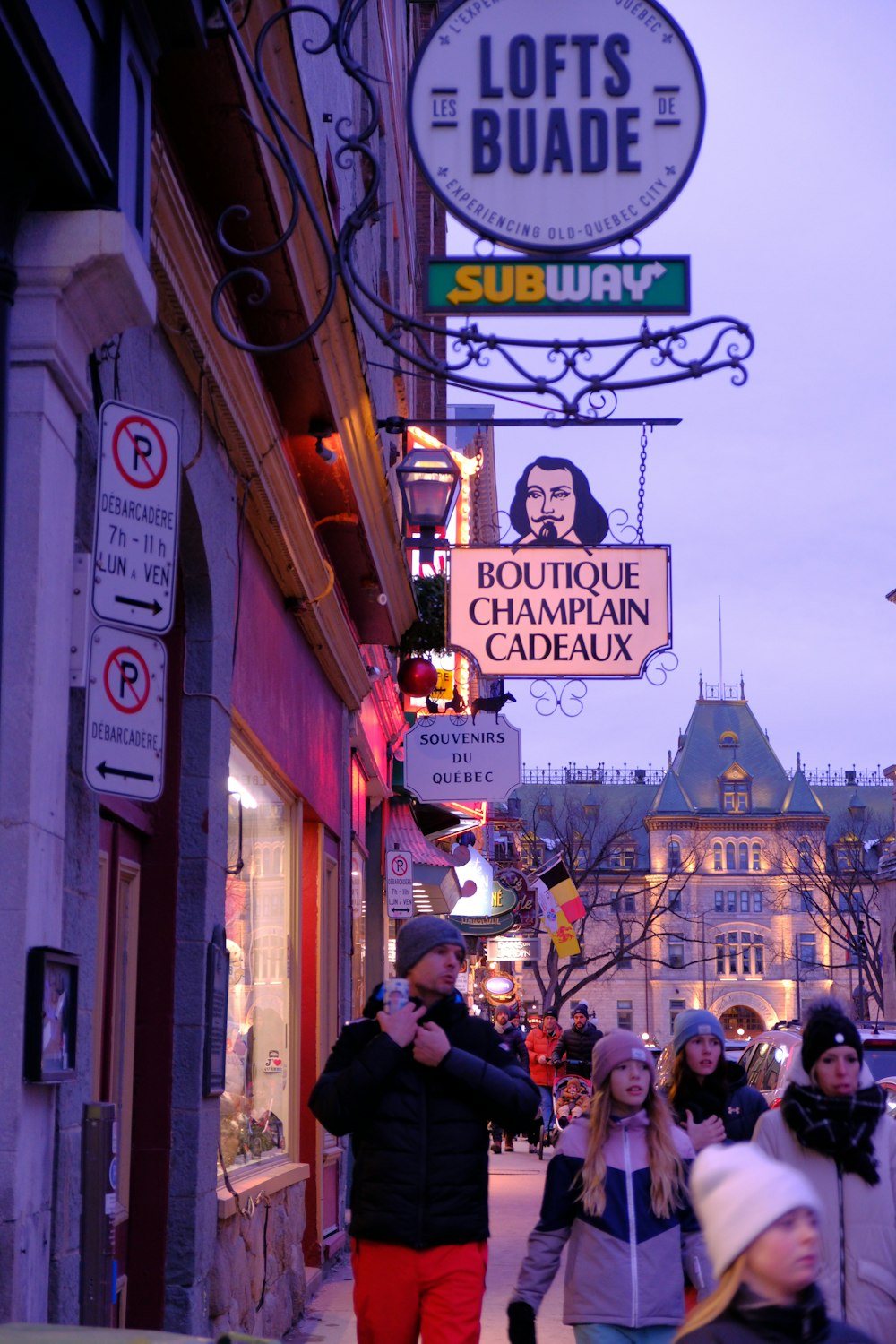 a group of people walking down a street next to a building