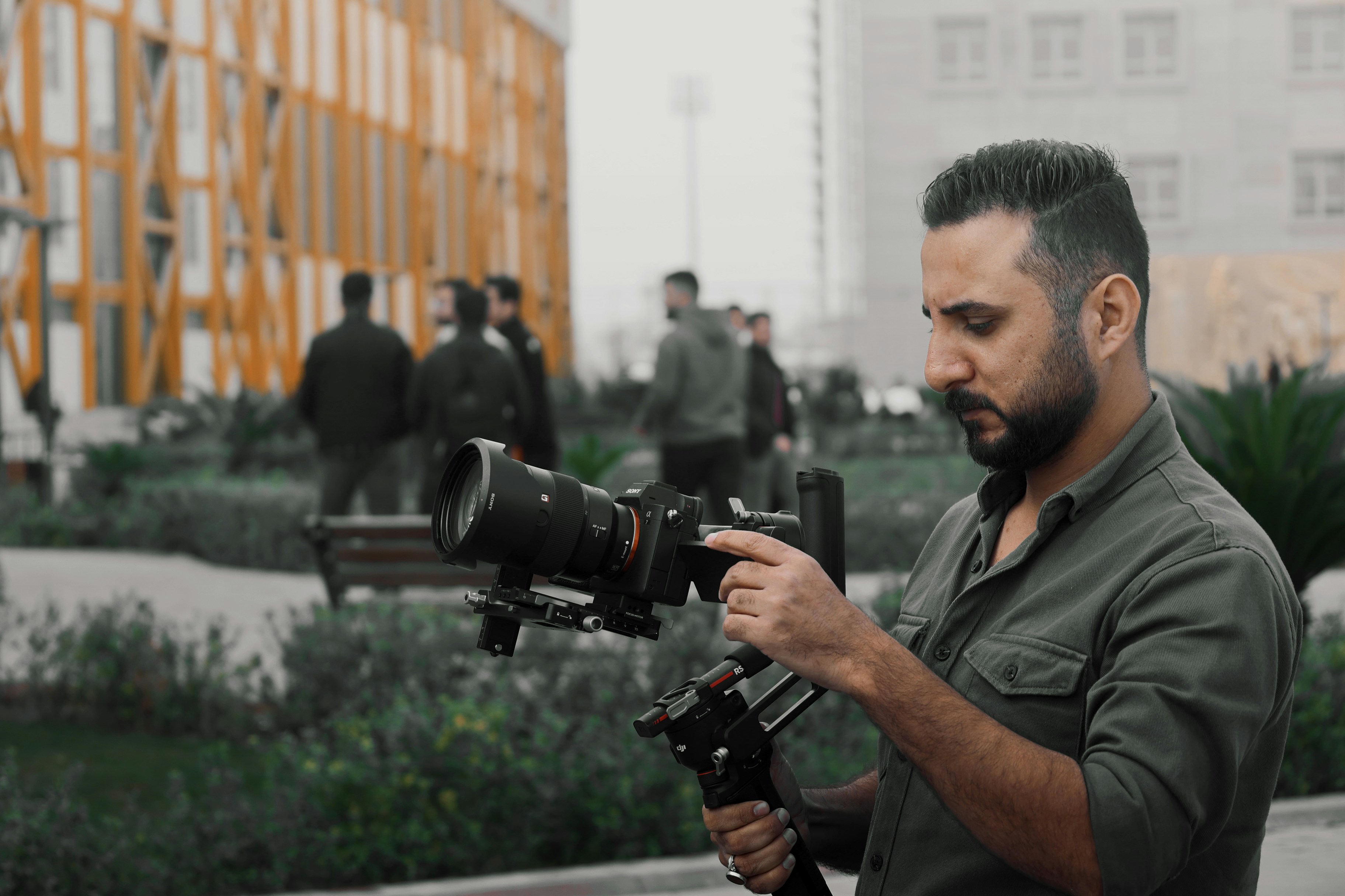 a man holding a camera in front of a building