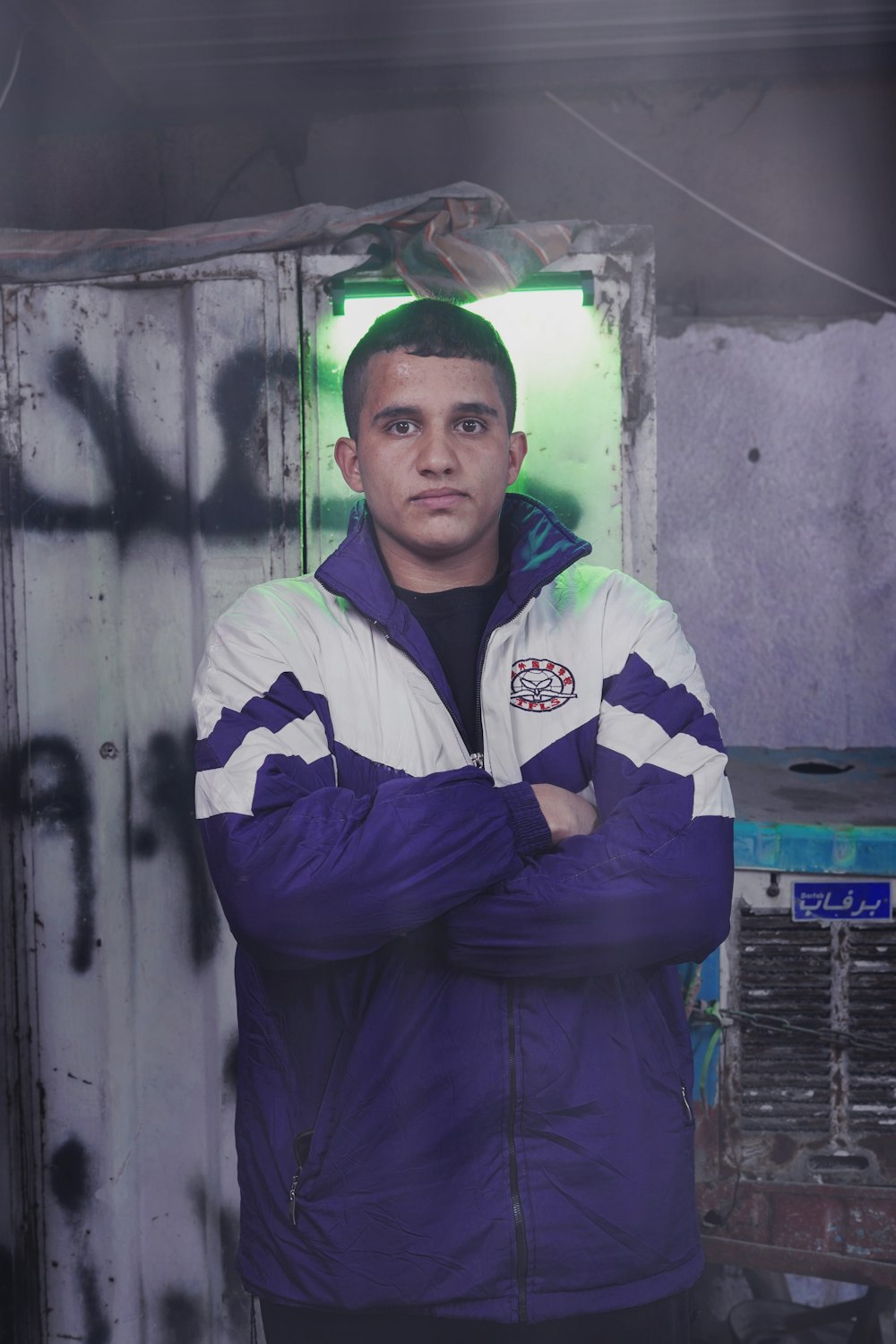 a man standing in front of a wall with graffiti on it