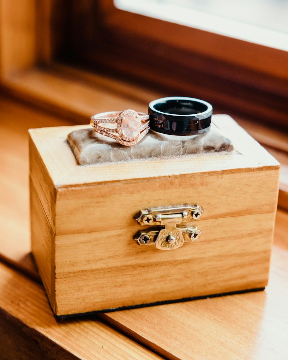 a wooden box with two rings on top of it