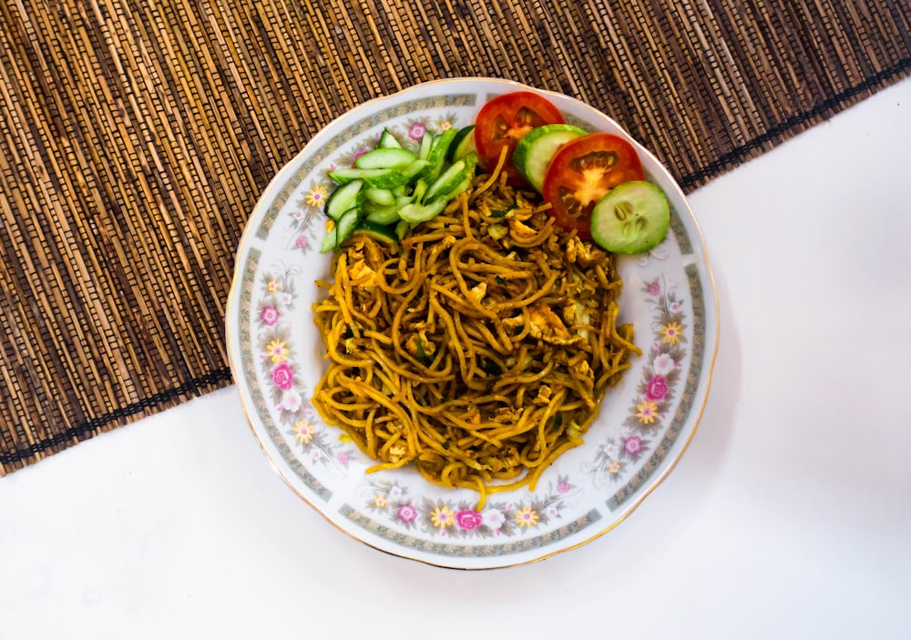 a plate of noodles and vegetables on a table