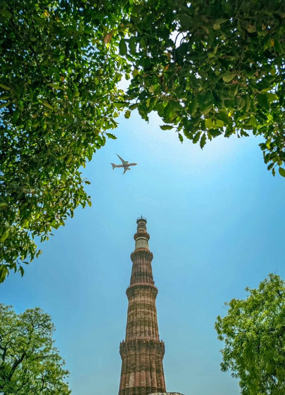 an airplane is flying over a tall tower