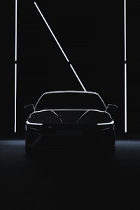 a car is shown in the dark with its lights on