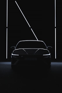 a car is shown in the dark with its lights on