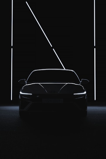 a car is shown in the dark with its lights on