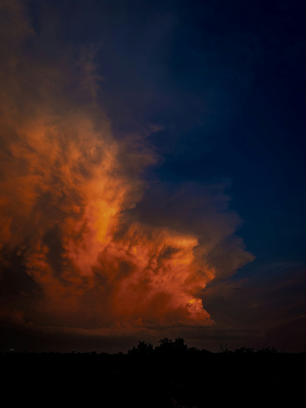 a plane flying in the sky with a sunset in the background