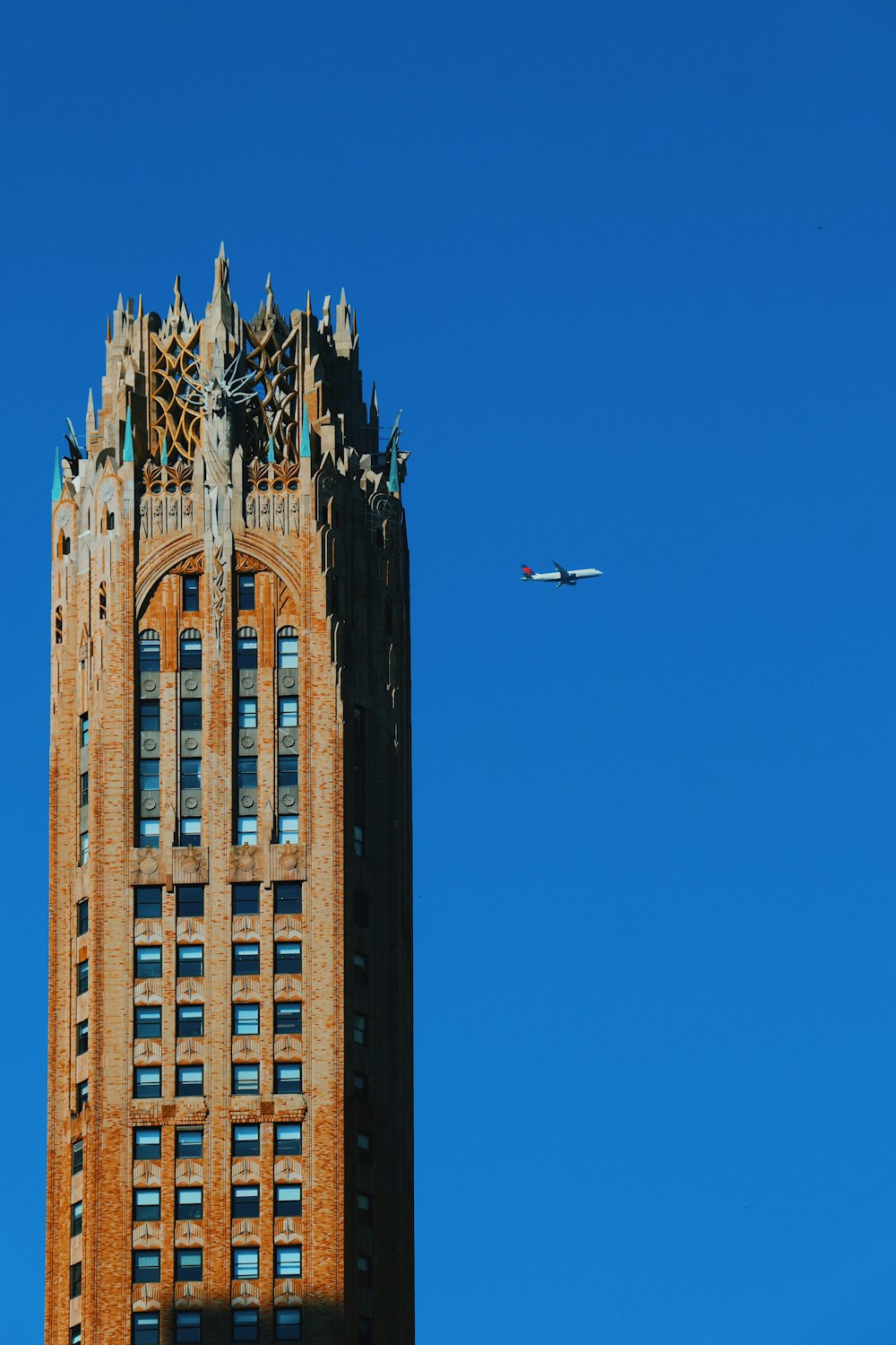 a large building with a plane flying in the sky
