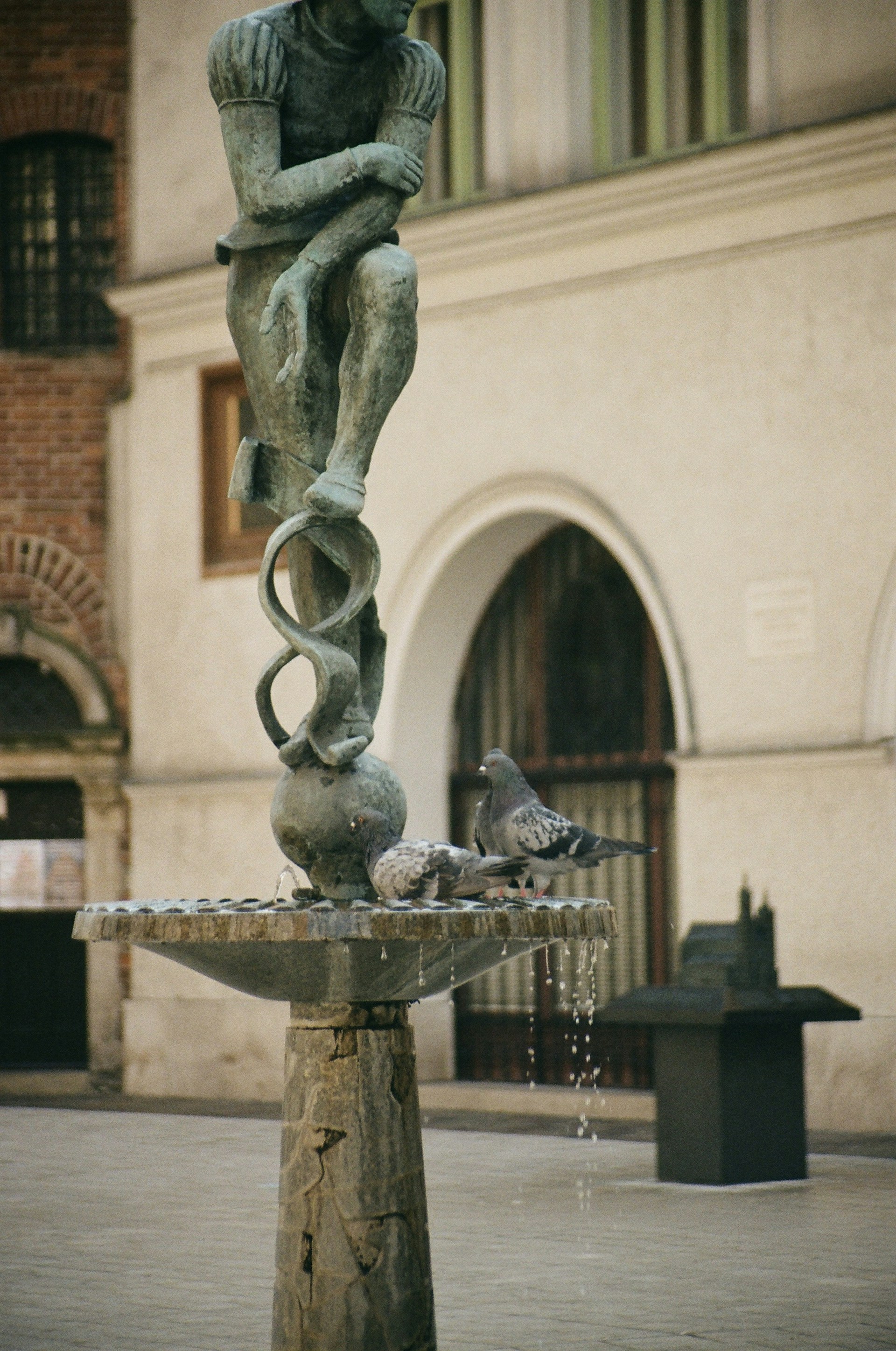 a statue of a man sitting on top of a fountain