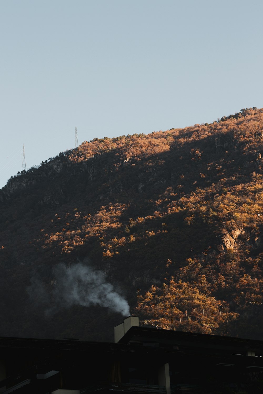smoke coming out of a chimney in front of a mountain