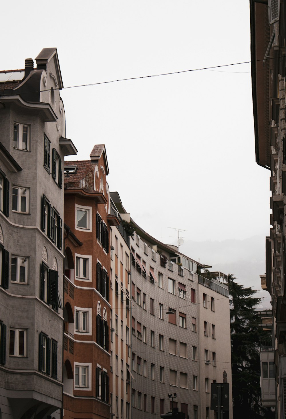 a clock on a pole in front of a row of buildings