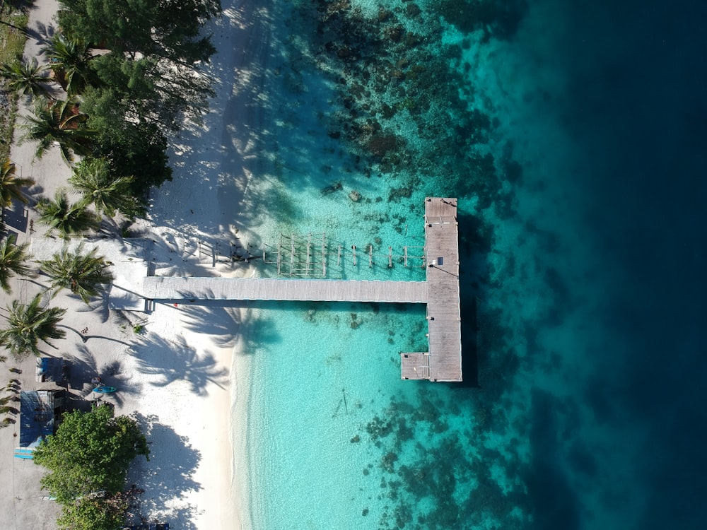 an aerial view of a beach with a pier