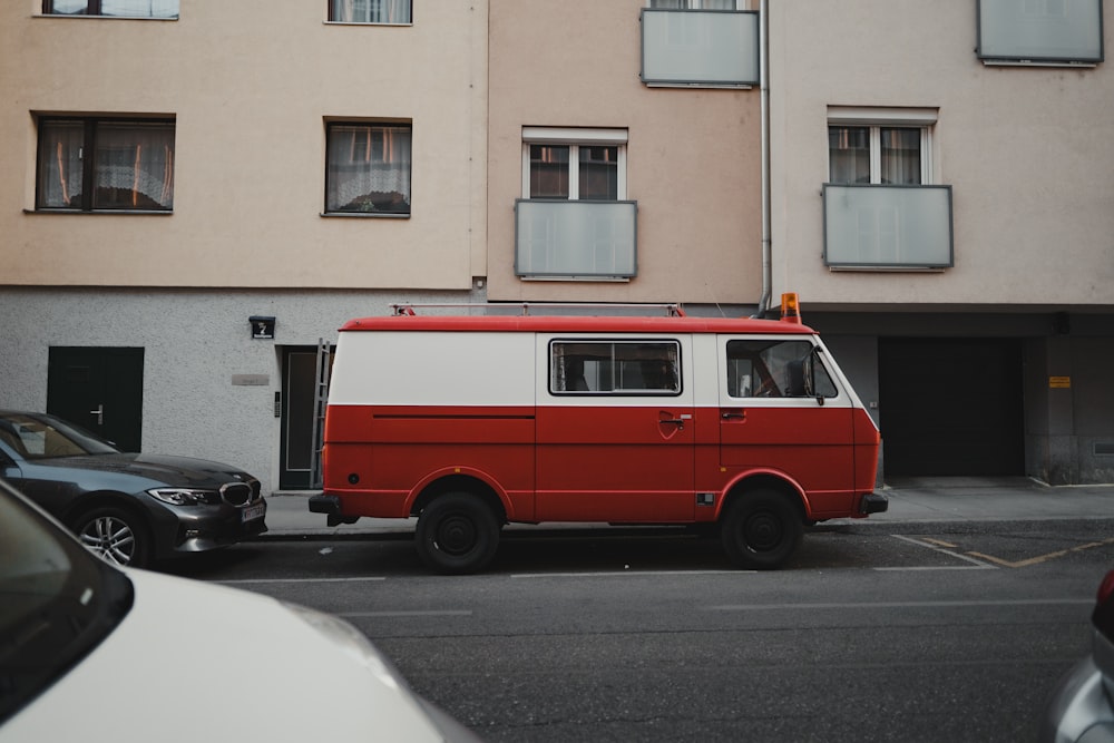 a red and white van parked in front of a building