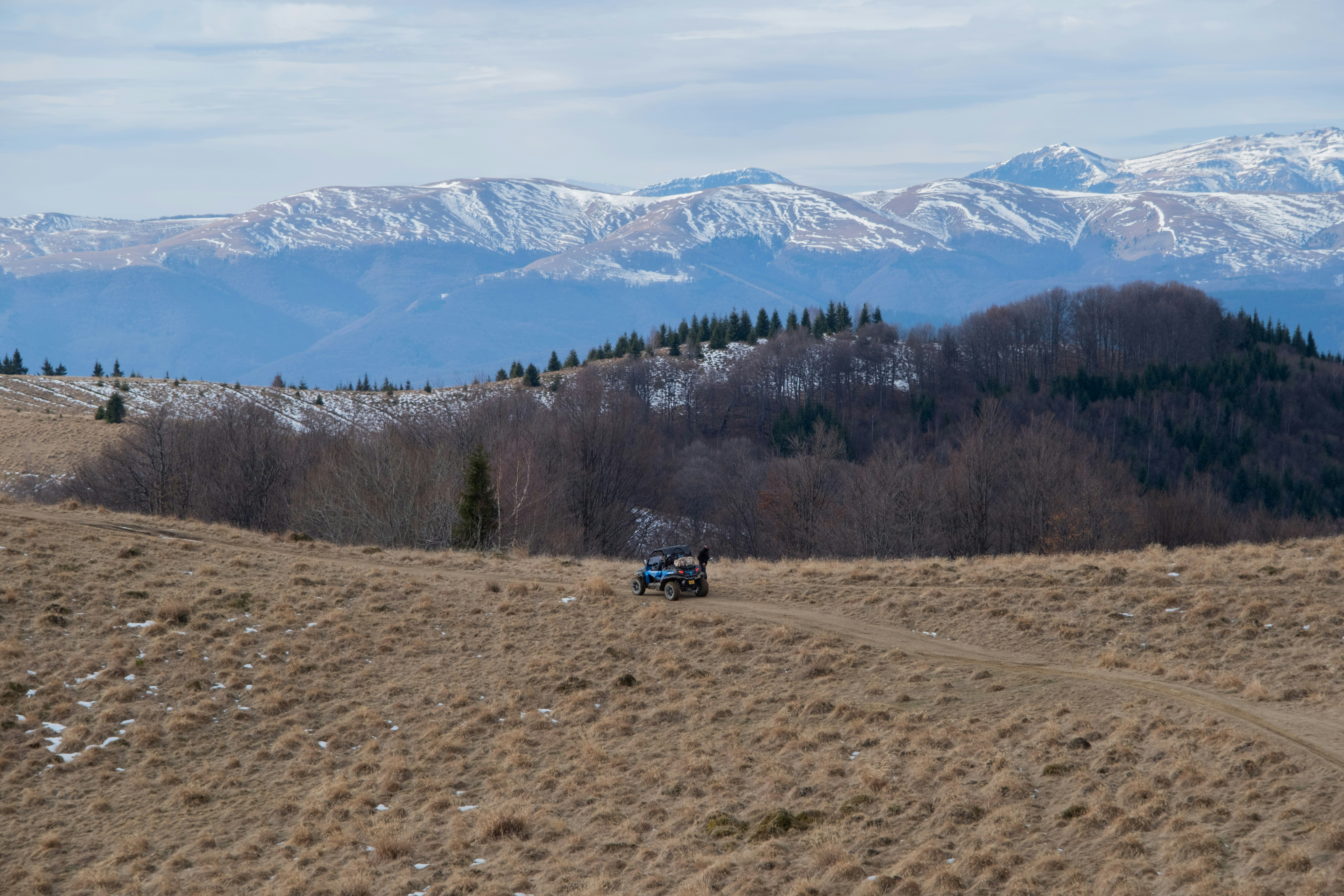 a truck driving down a dirt road in the mountains