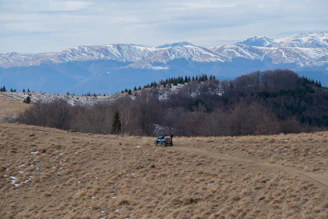 a truck driving down a dirt road in the mountains