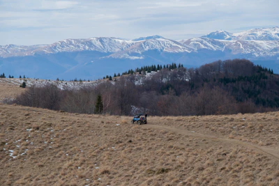 a truck driving down a dirt road in the mountains