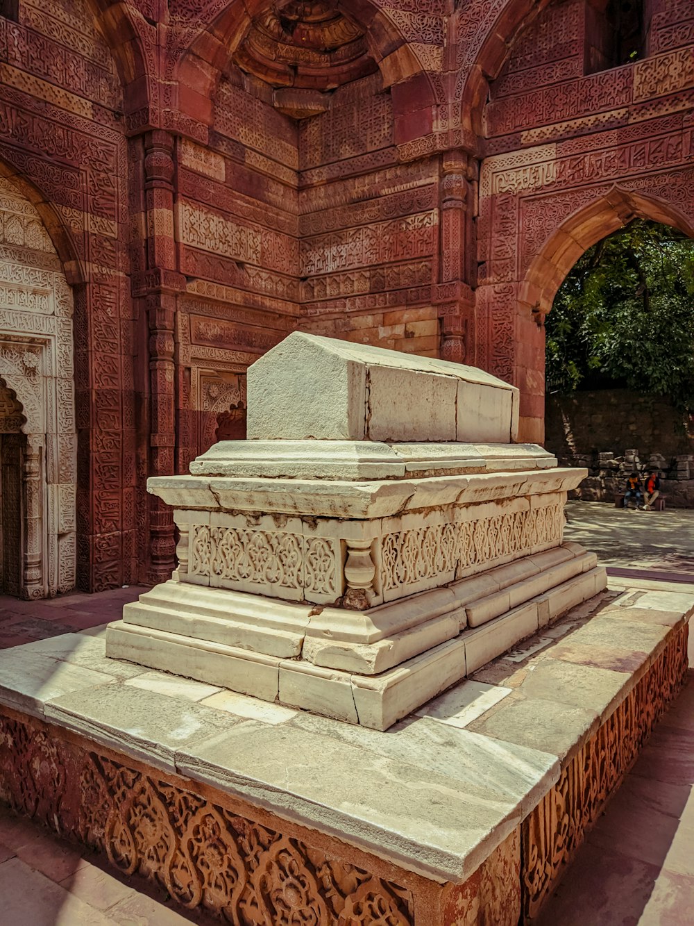 a stone monument in a courtyard with arches