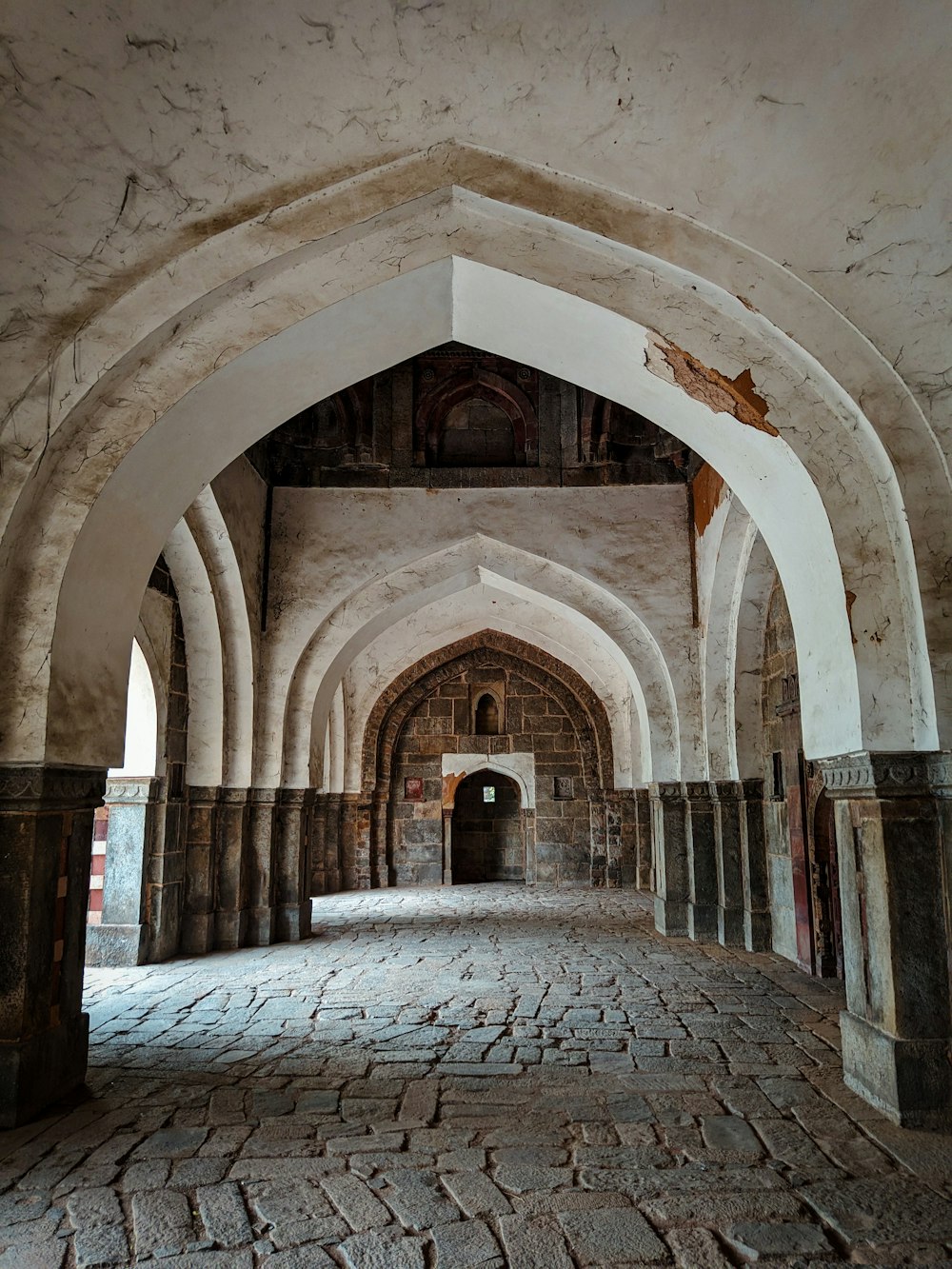 an old building with a stone floor and arches