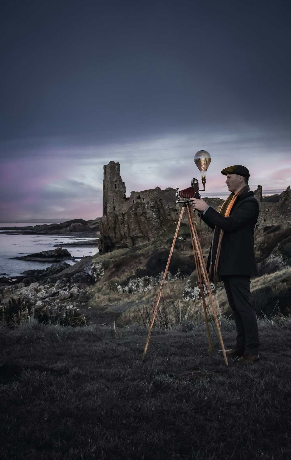 a man standing in a field holding a camera