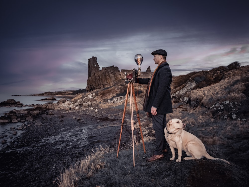 a man standing next to a dog on top of a field