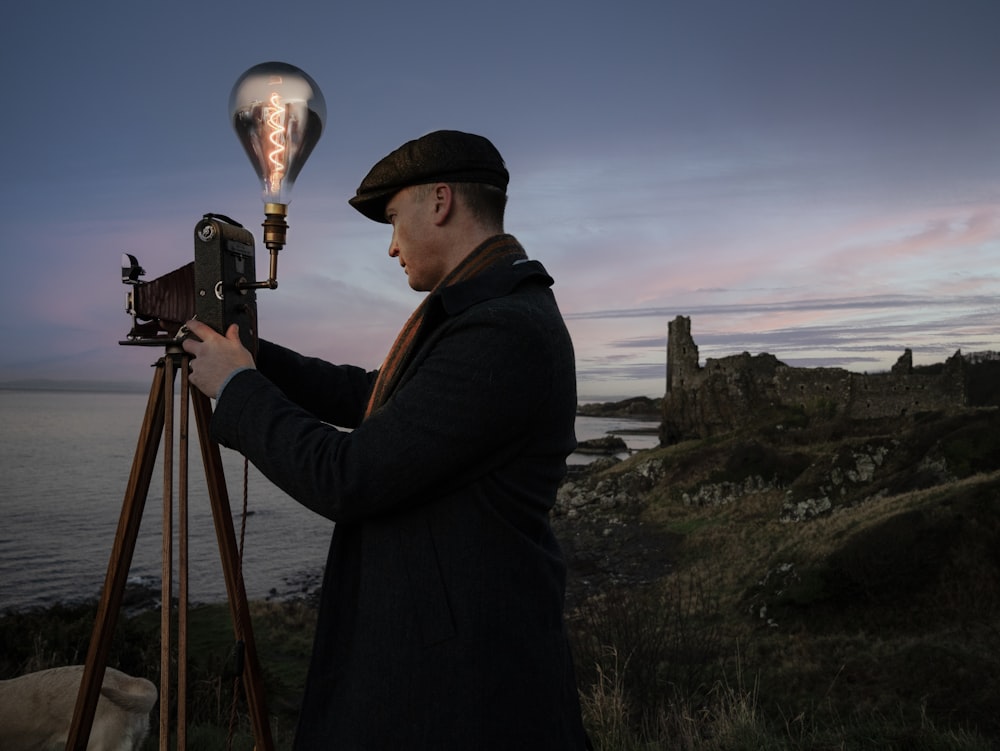 a man standing next to a camera on top of a tripod