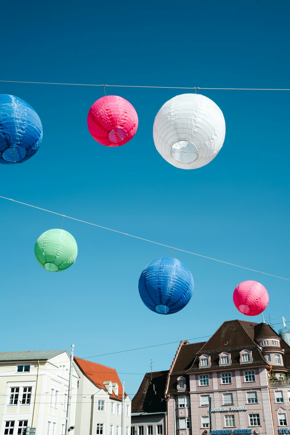 a group of paper lanterns hanging from a wire