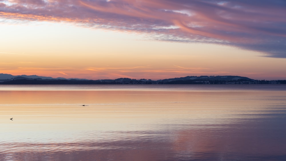 a large body of water with mountains in the background