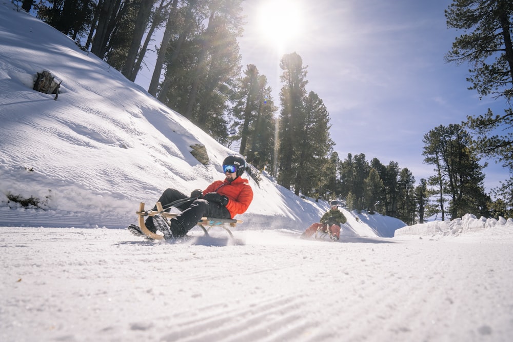 a man riding a snowboard down a snow covered slope