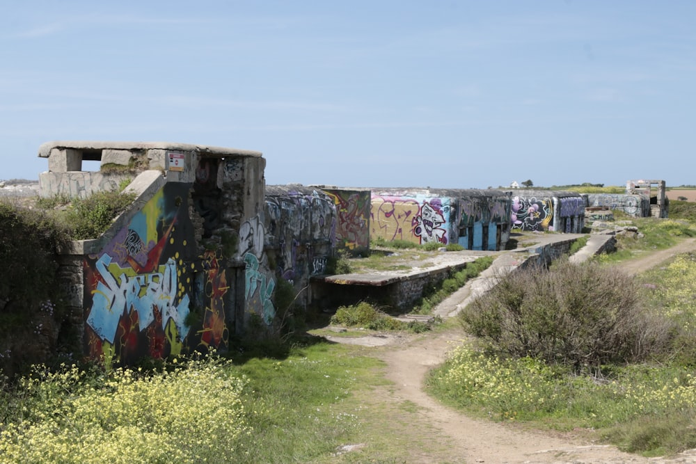 a dirt road with graffiti on the side of it