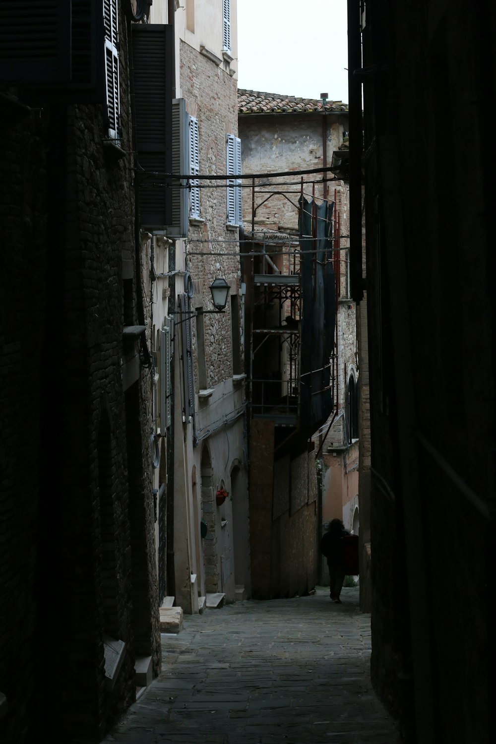 a narrow alley way with a clock tower in the distance