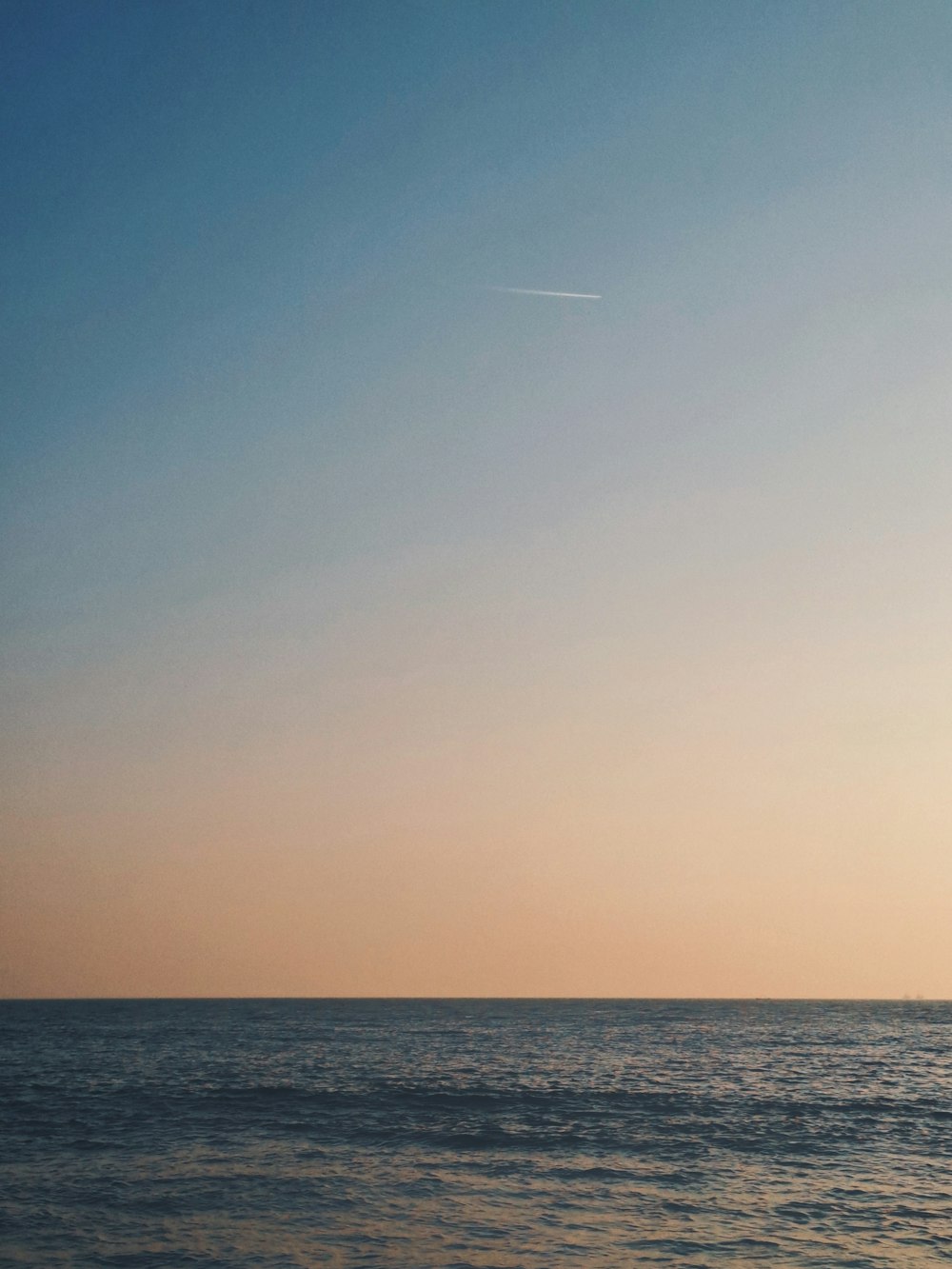 a person on a surfboard in the ocean at sunset