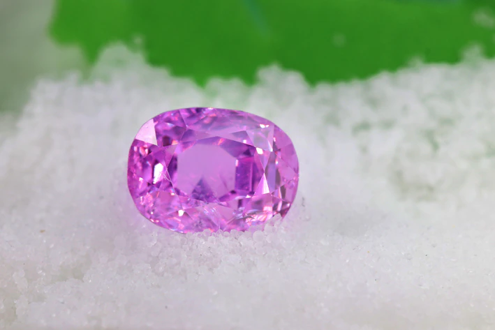 a pink diamond sitting on top of a pile of snow