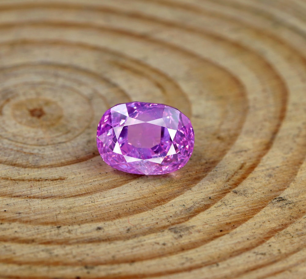 a pink diamond sitting on top of a wooden table