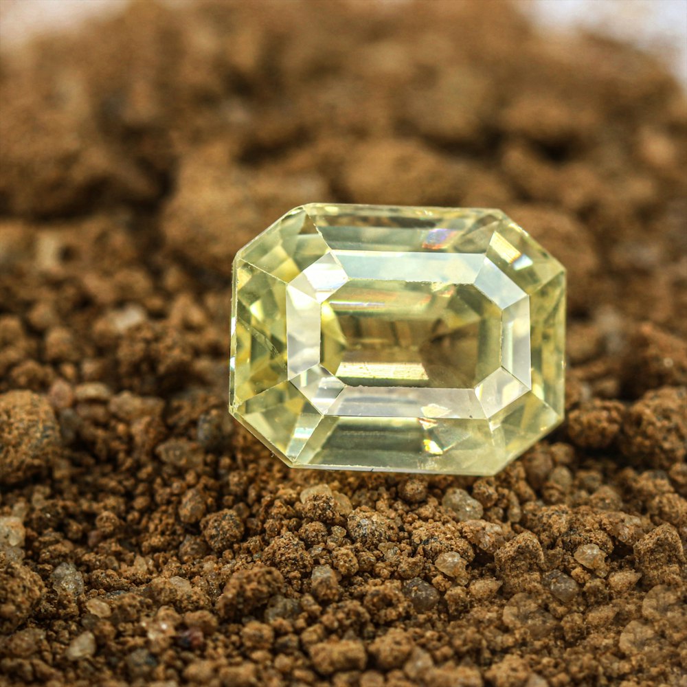 a yellow diamond sitting on top of a pile of dirt