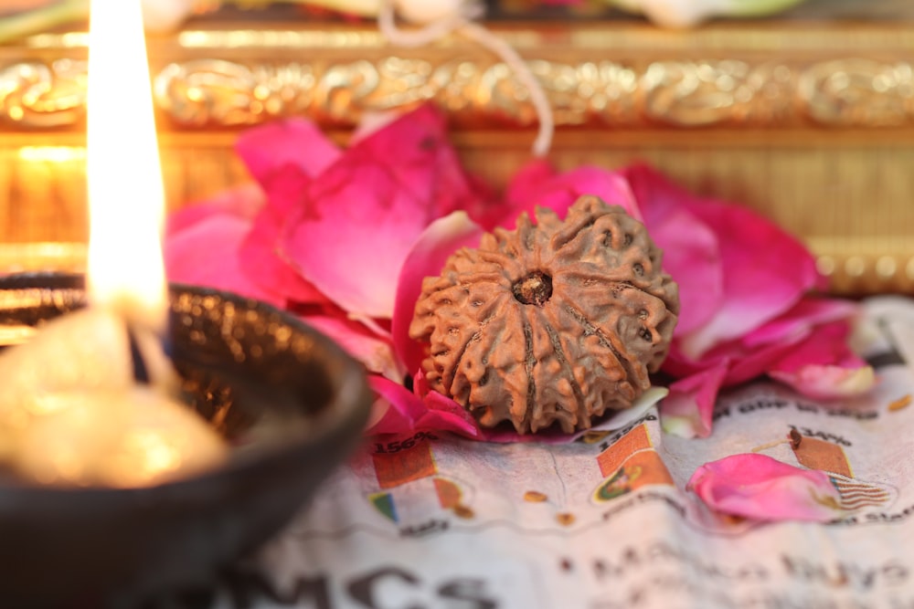 a candle and some pink flowers on a table