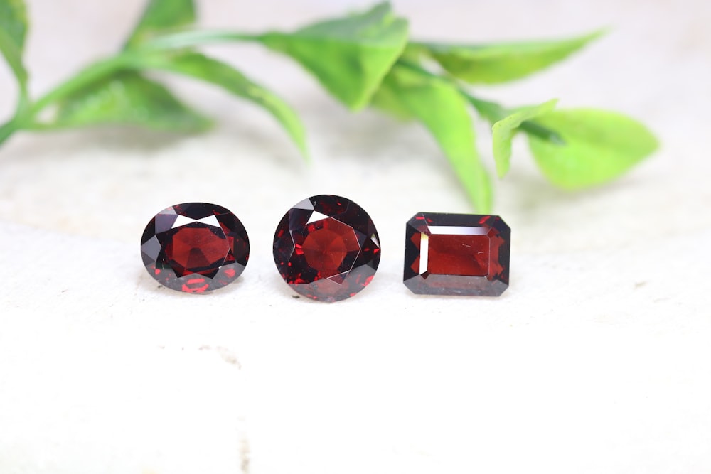 a group of three different colored stones on a white surface