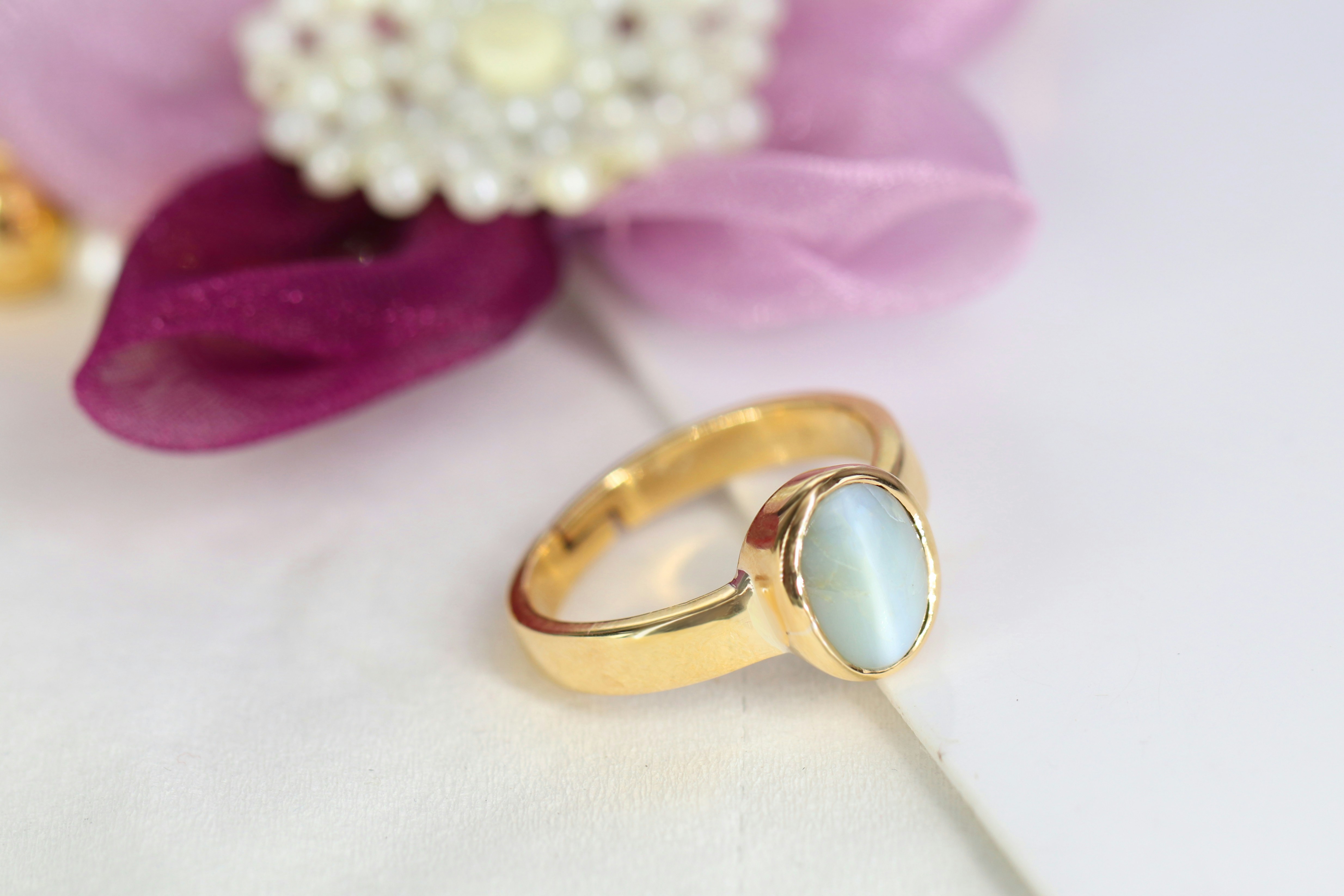 un gros plan d’une bague avec une fleur en arrière-plan