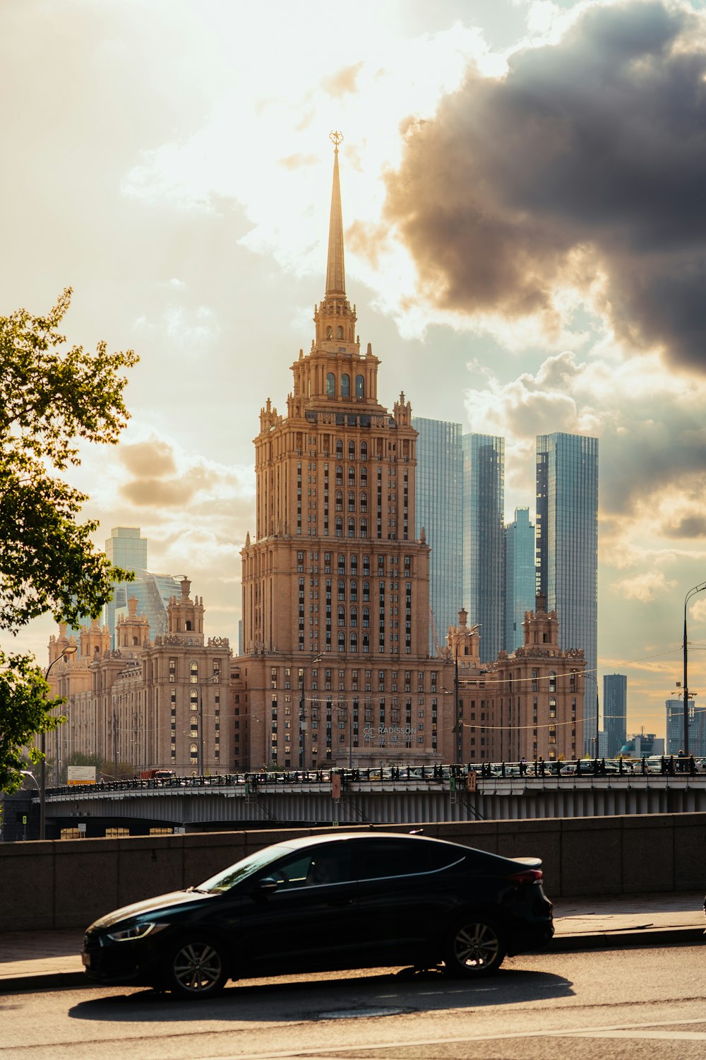 a black car driving down a street next to tall buildings