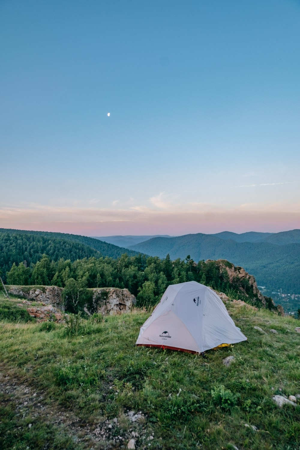 a tent pitched up on a grassy hill