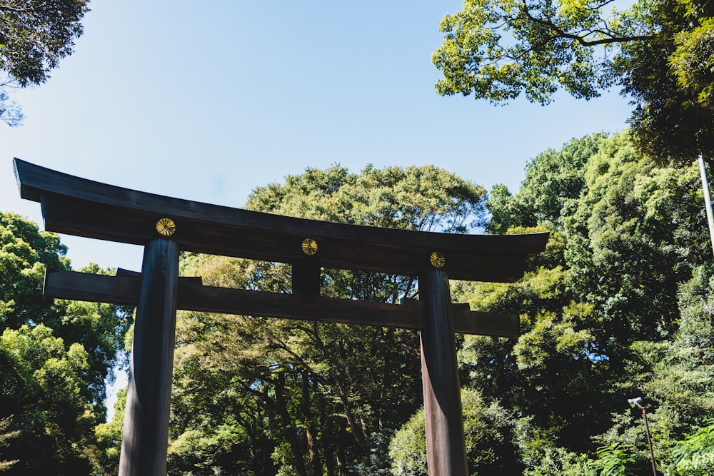 a large wooden gate in front of a forest