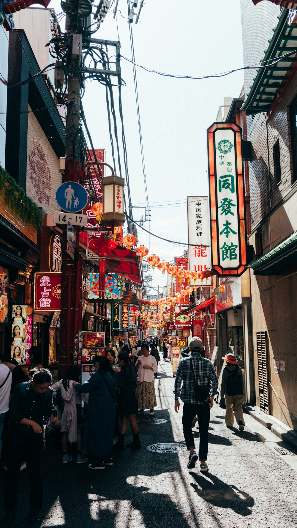 a group of people walking down a street next to stores