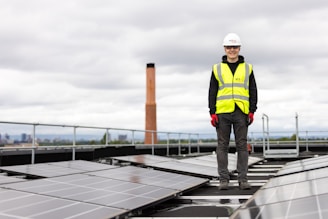 a man standing on top of a roof with solar panels