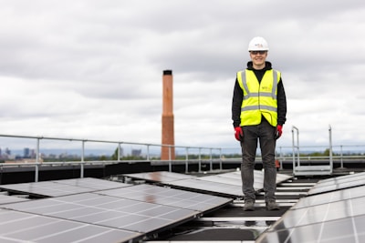 a man standing on top of a roof with solar panels