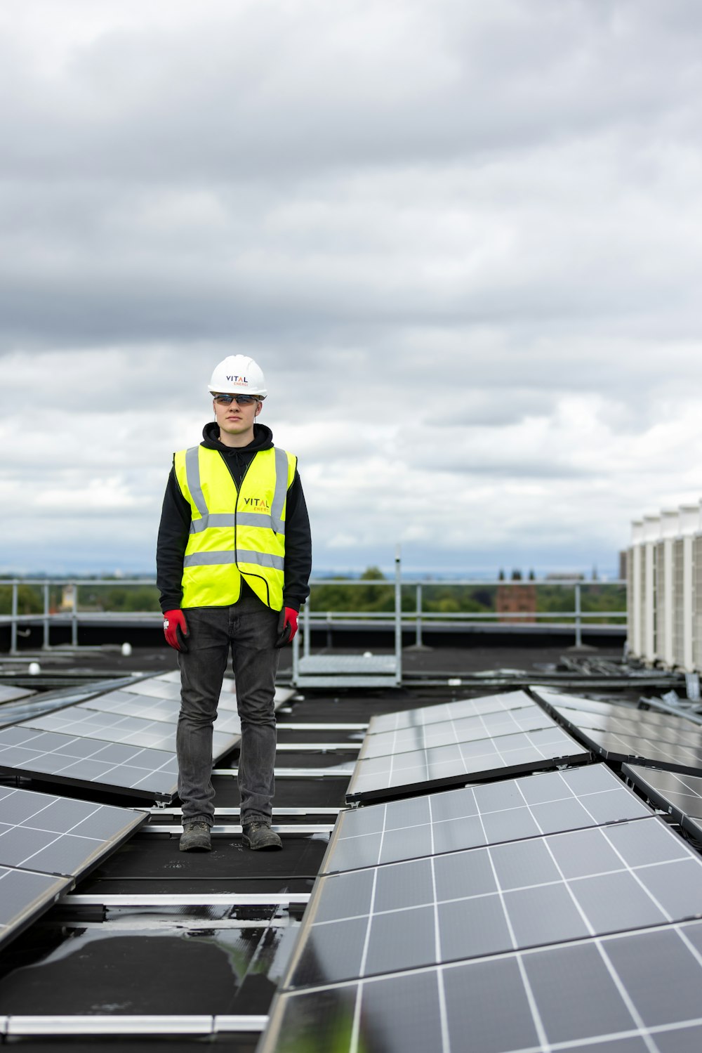 a man standing on top of a roof covered in solar panels