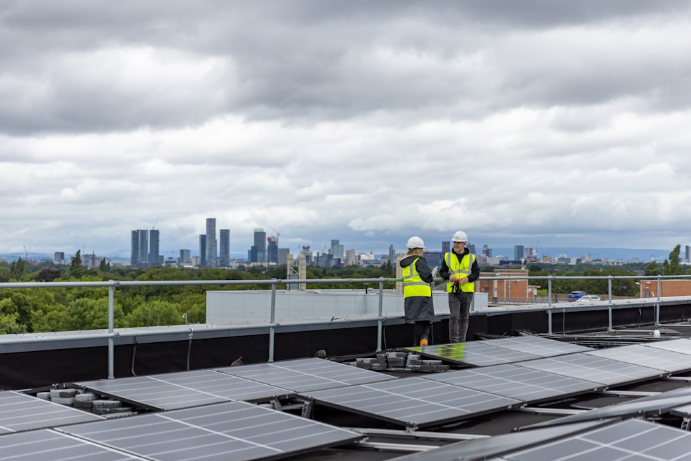 a couple of men standing on top of a roof