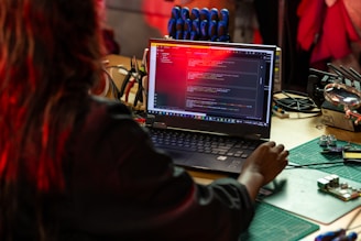 a woman sitting in front of a laptop computer